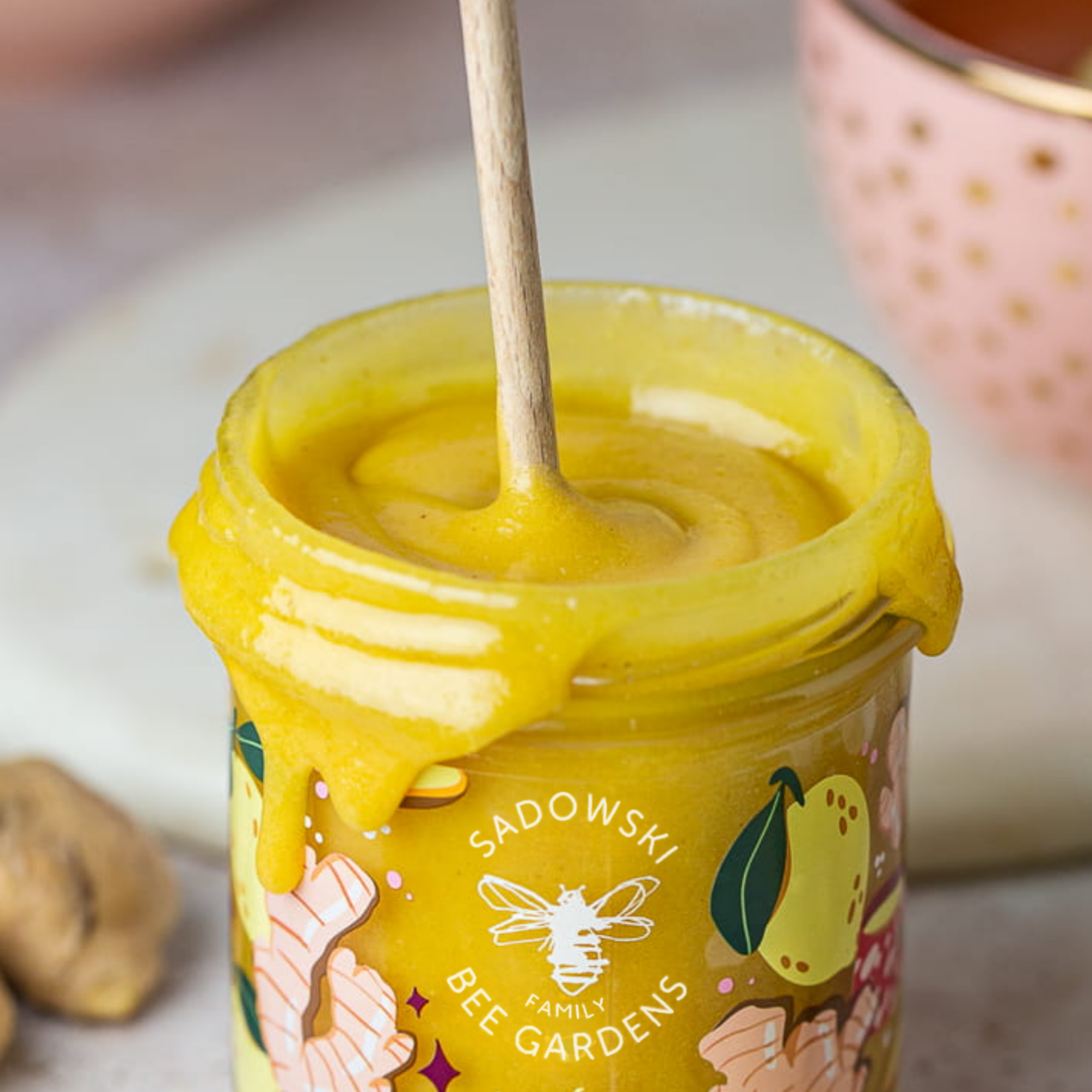 Close up of lemon ginger honey texture dripping from jar – Honey & Bloom Singapore